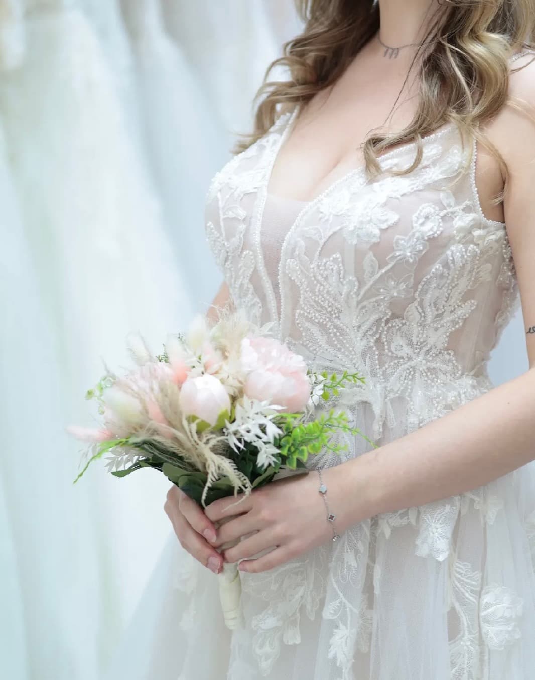 Braut mit Blumenstrauß in einem Spitzenkleid — Neue Brautkleid-Kollektion bei Liebesgeschichte