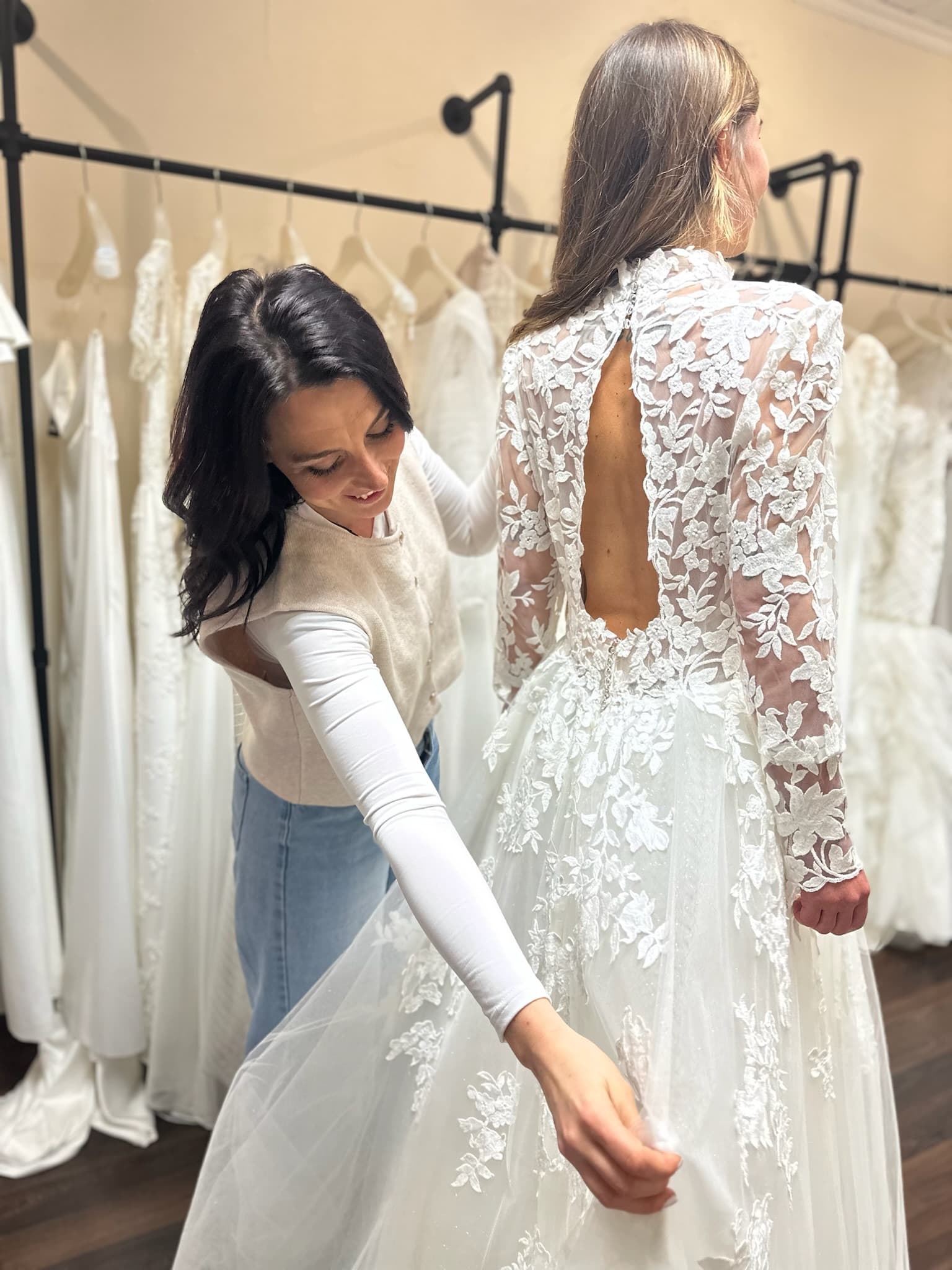 Persönliche Brautmodeberatung — Inhaberin Melanie hilft einer Braut beim Ankleiden im Atelier Liebesgeschichte